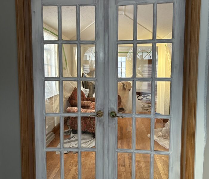 Natural wood french doors primed with paint.