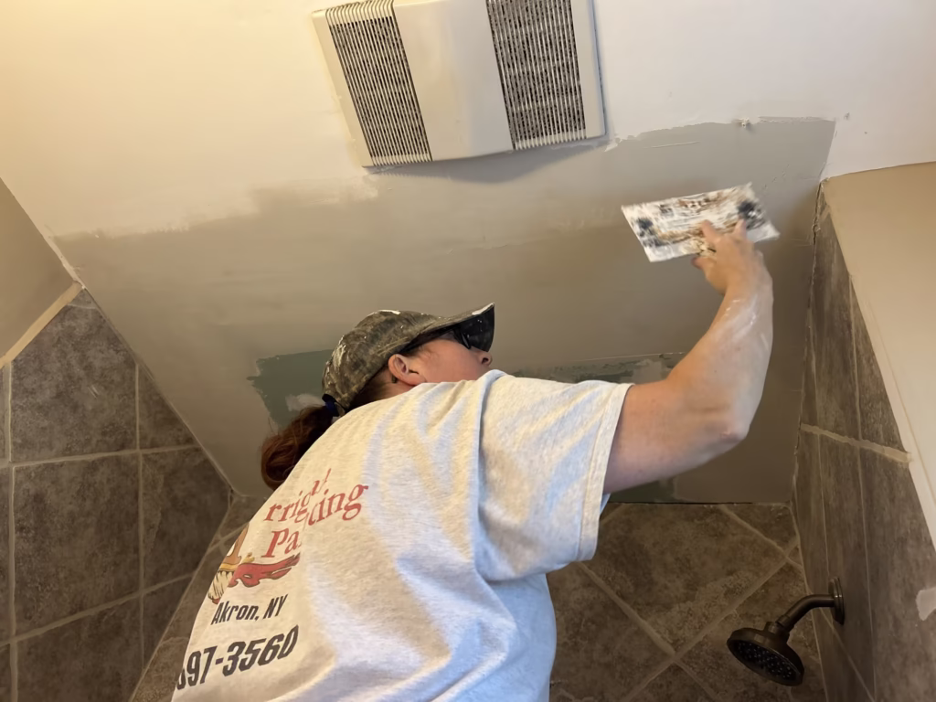 Bathroom Ceiling Repair in Williamsville 5 finishing a drywall ceiling patch in a bathroom in a Williamsville home.