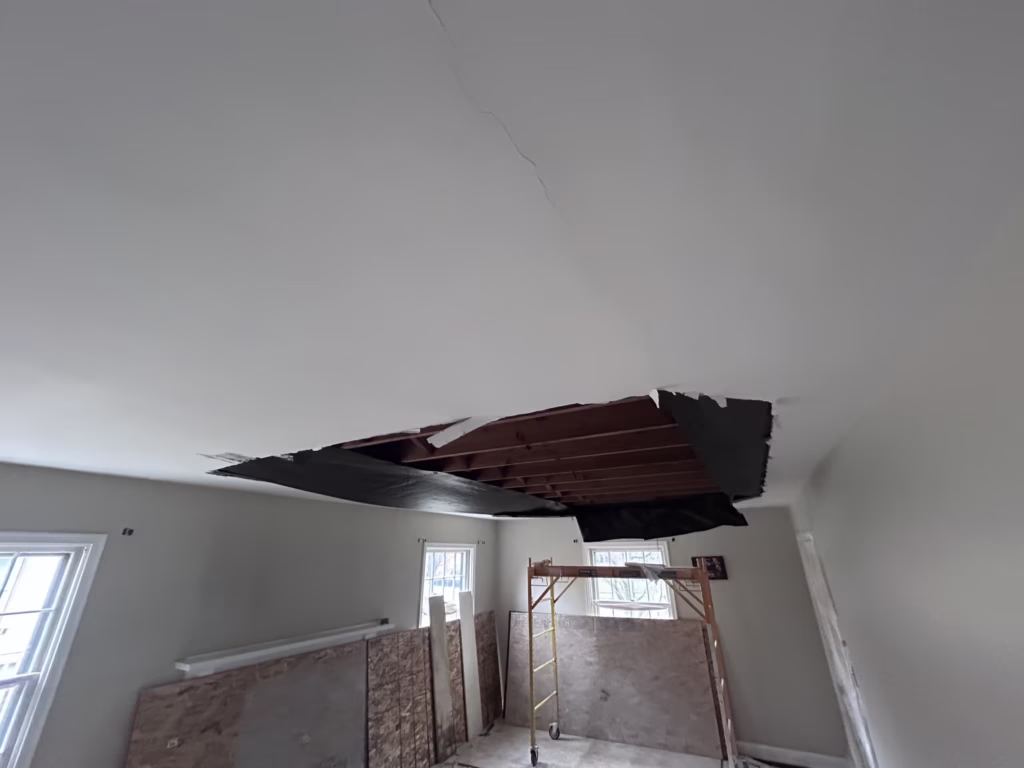 Rocklath plaster ceiling collapse in a living room with tar paper above the ceiling