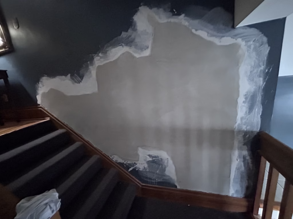 Large plaster wall patch finished with lime and plaster of paris