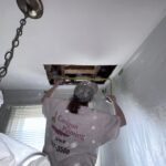 Taking measurements for a ceiling repair.